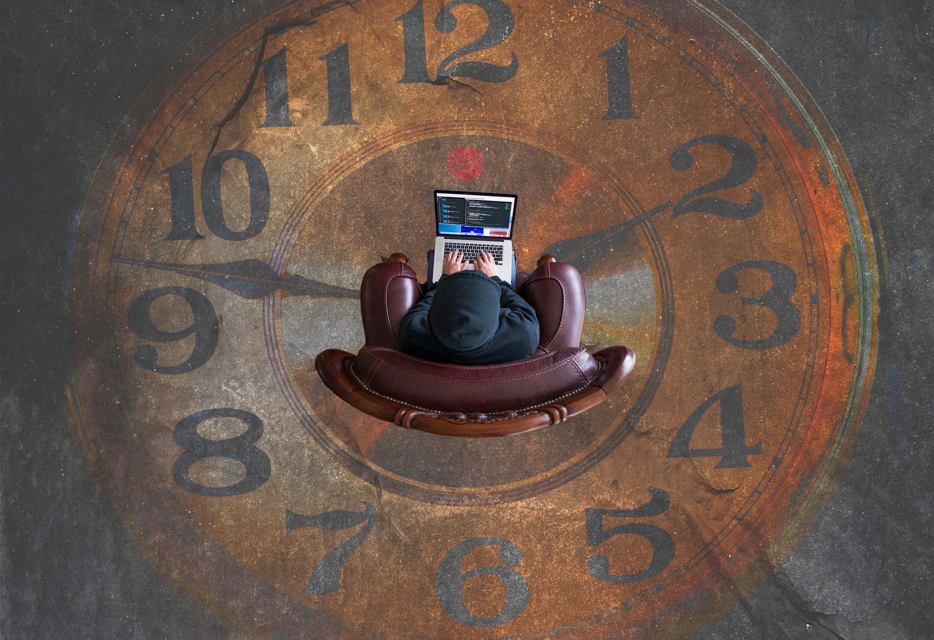 Aerial photo of customer in a chair using a laptop over a large clock representing customer lifetime value