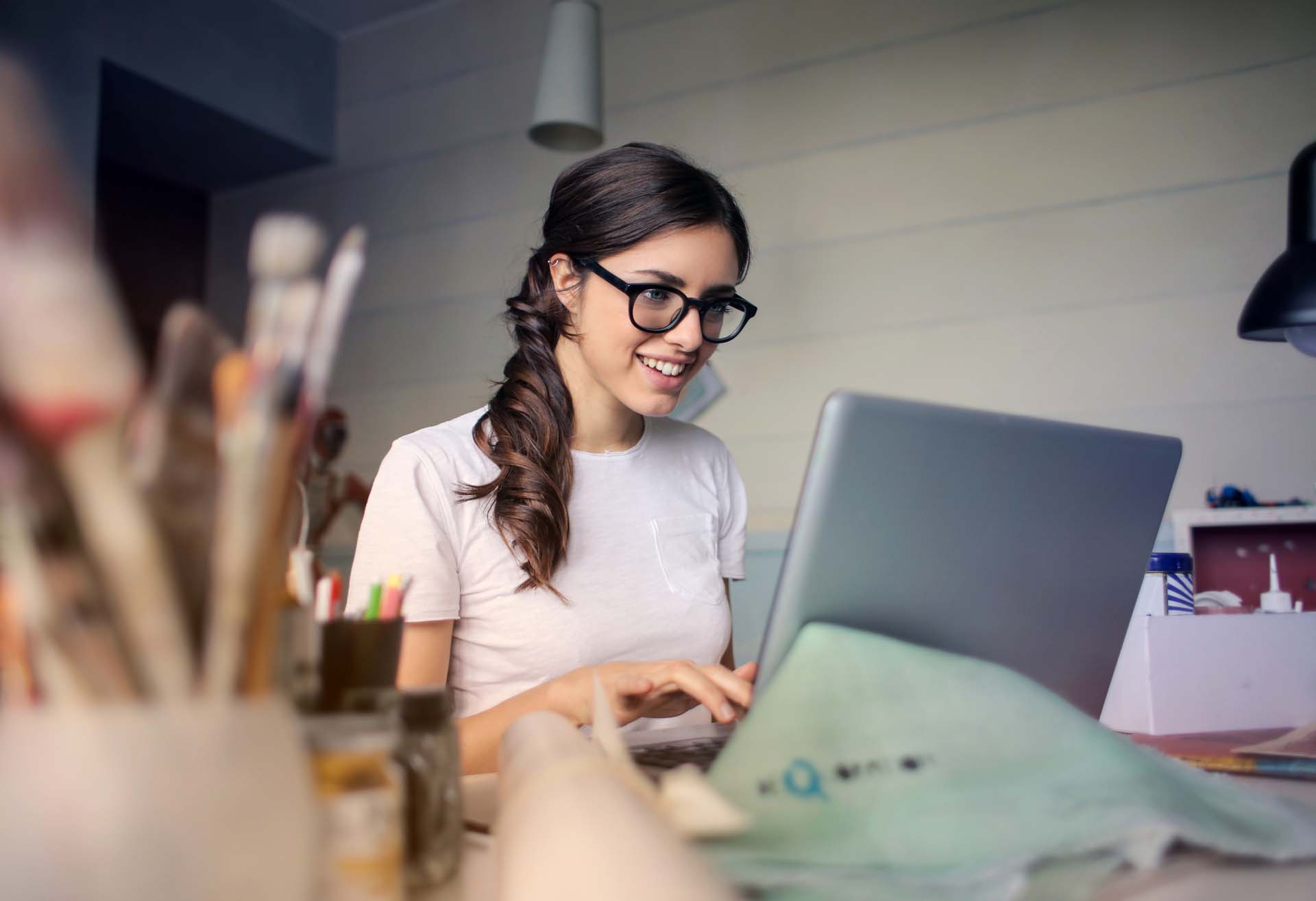 Woman in a studio typing on a laptop