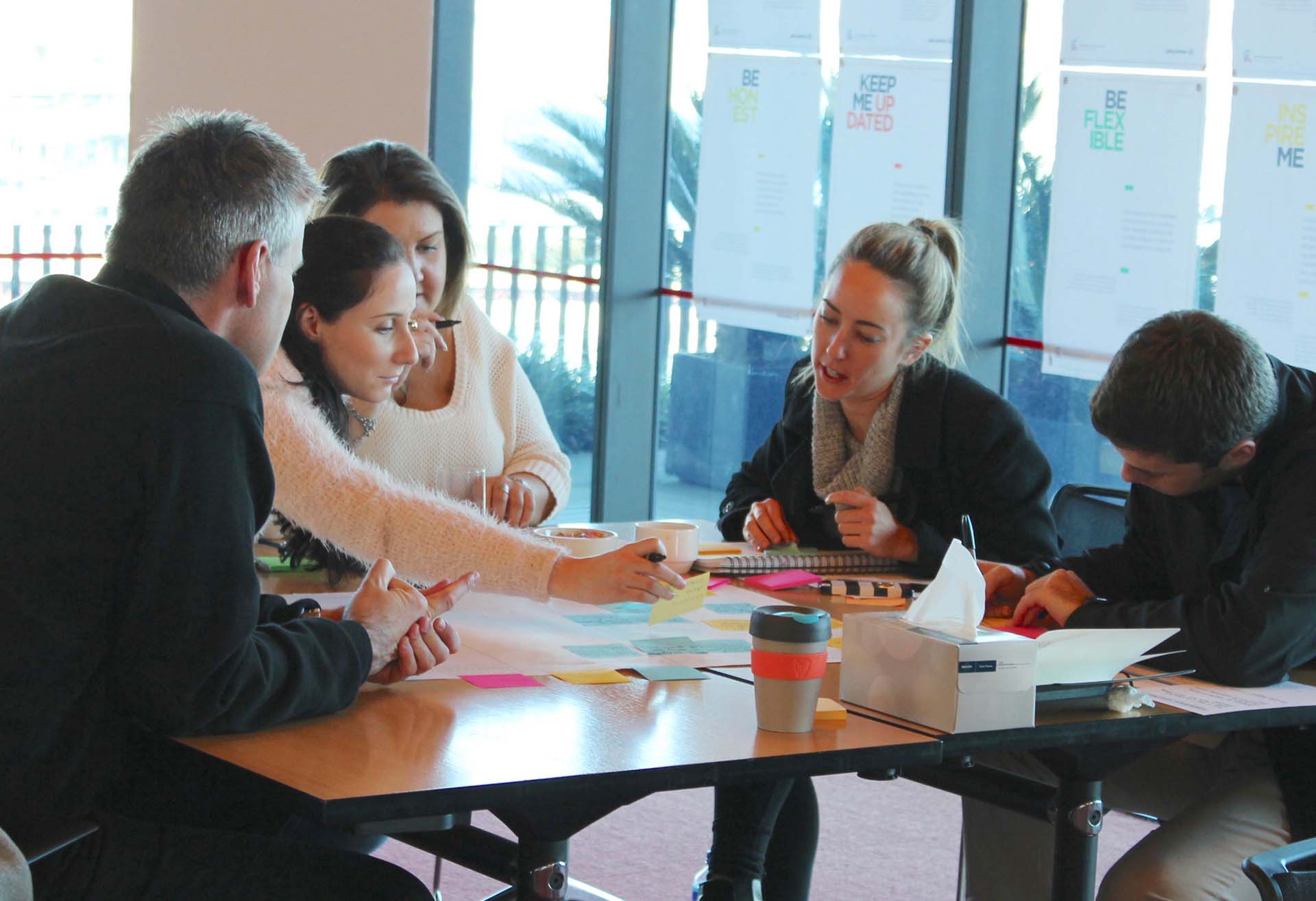 Proto employees seated around table brainstorming.