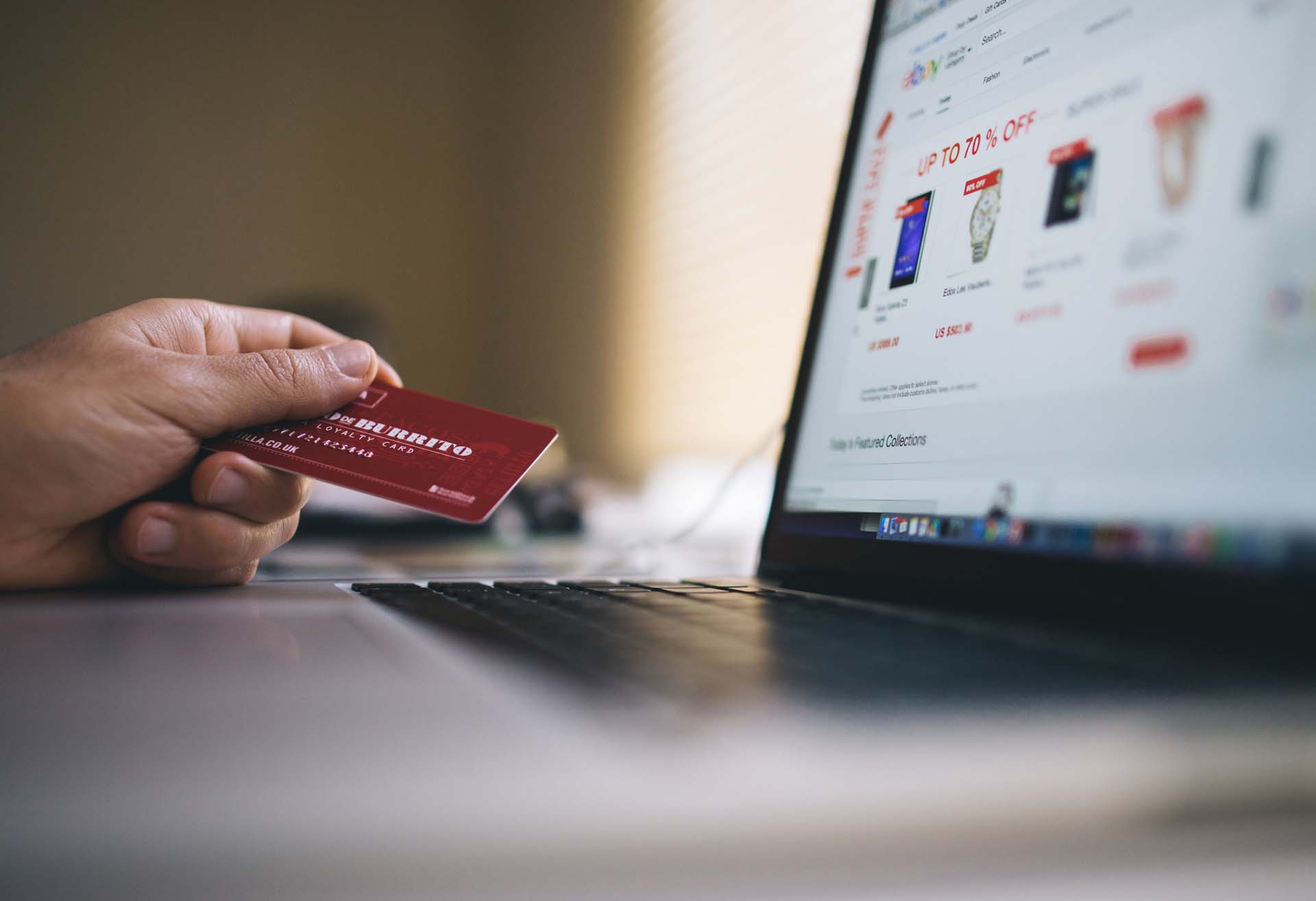 Hand holding a credit card whilst using ecommerce platform