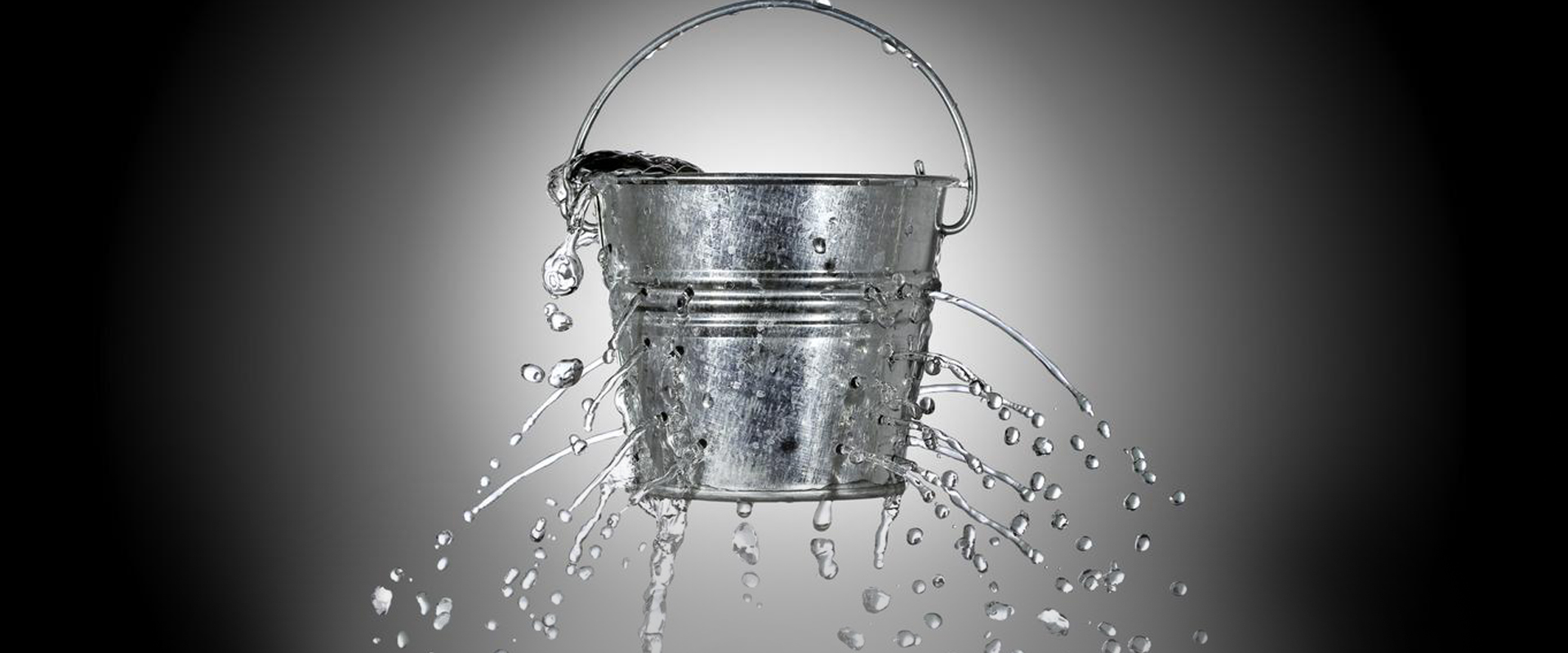 A bucket which is leaking due to many holes punctured in its metal.