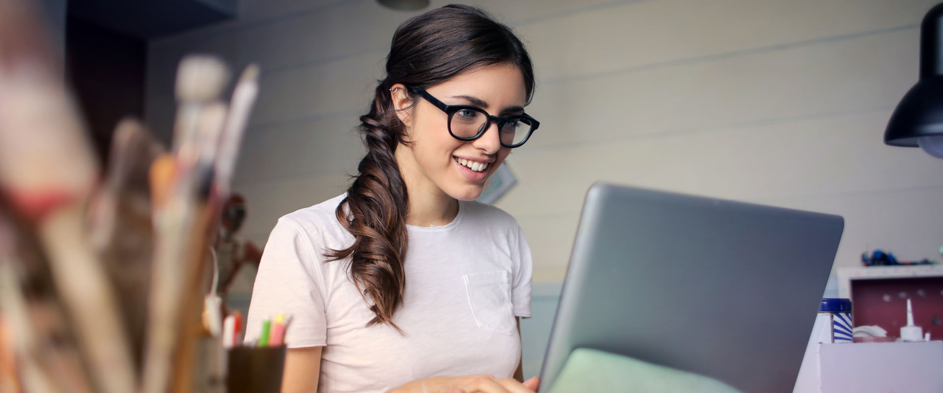 Woman in a studio typing on a laptop