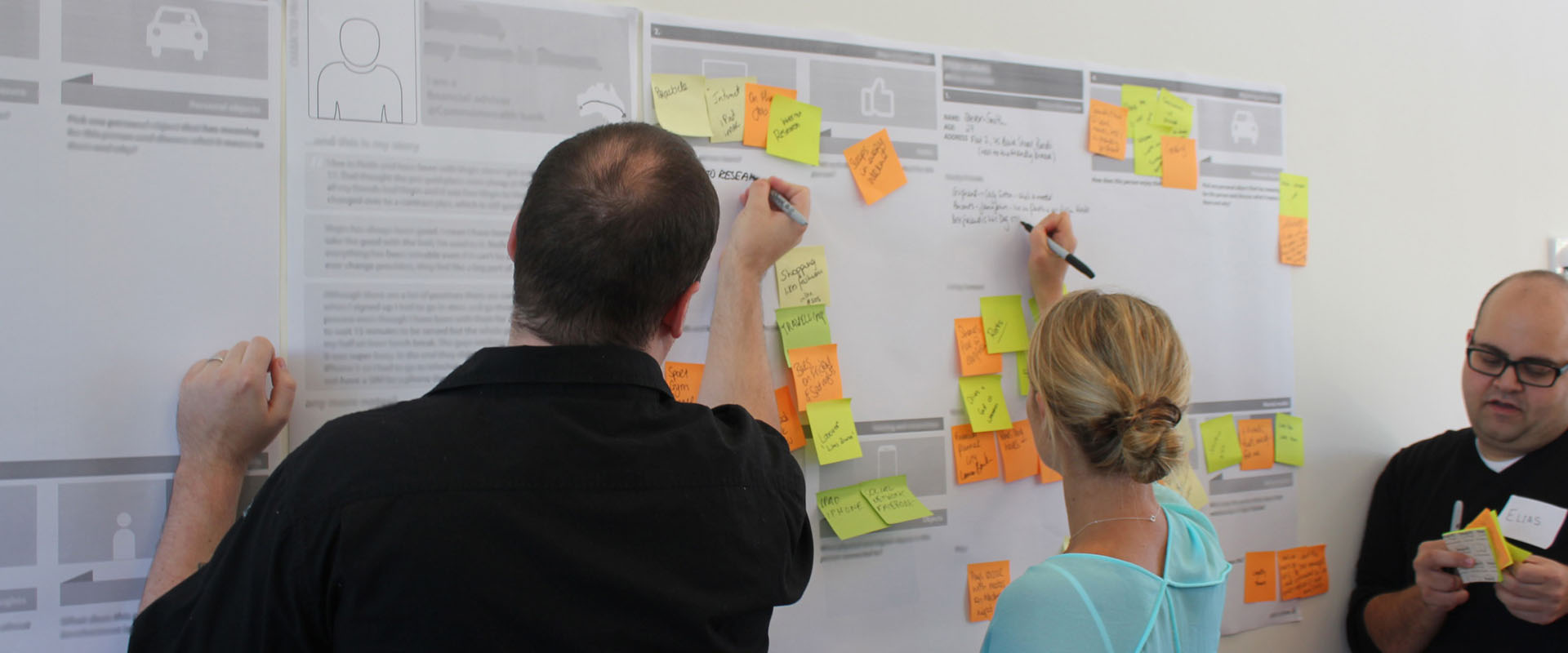 Three Proto employees making notes on a Customer Journey Map