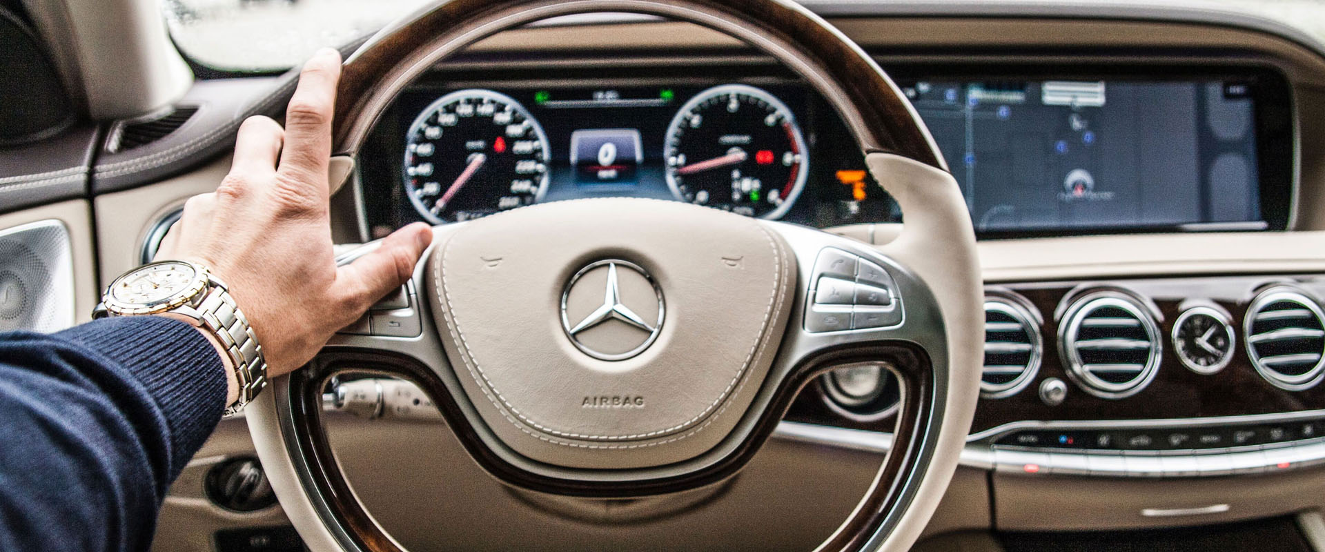 Hand on a Mercedes Benz steering wheel