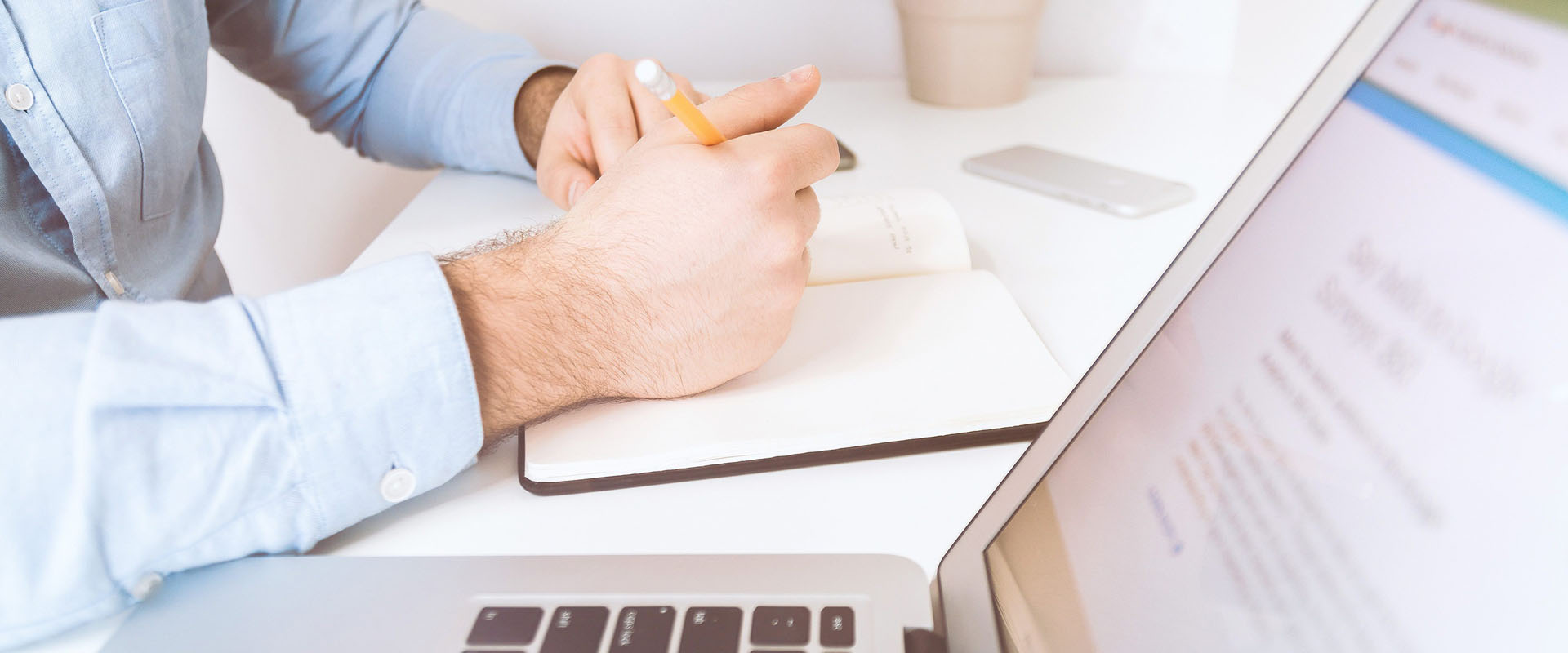 Man writing Digital Marketing Insights next to an open laptop