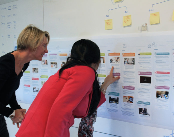 2 women standing in front of a CJM pointing at details